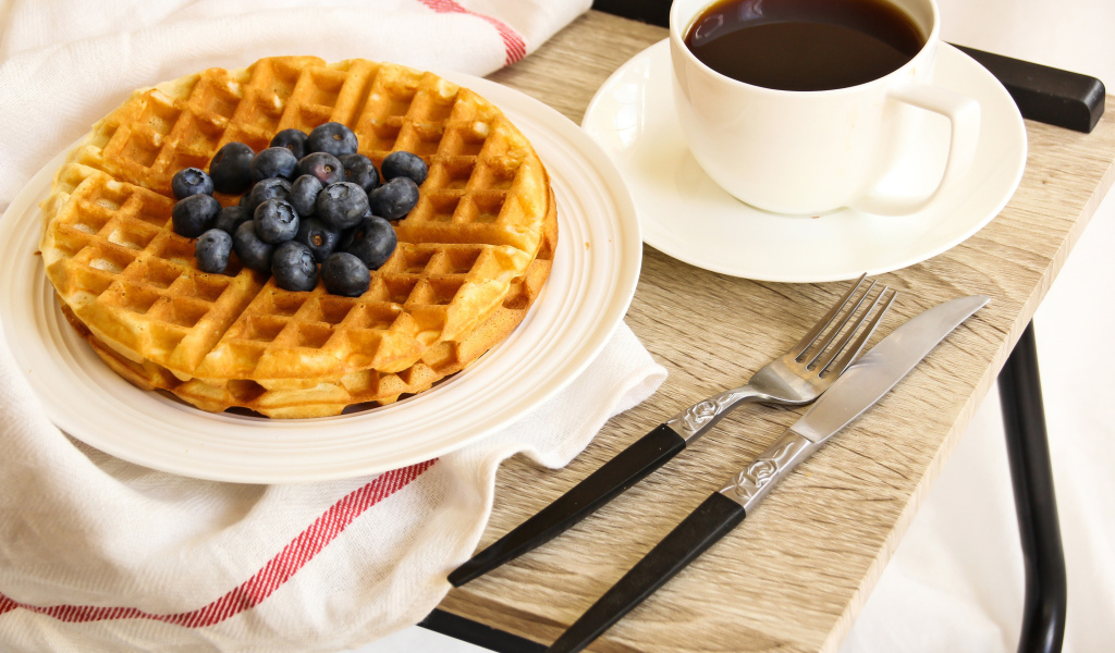 Сладкие вафли с черникой и чашкой кофе на завтрак
