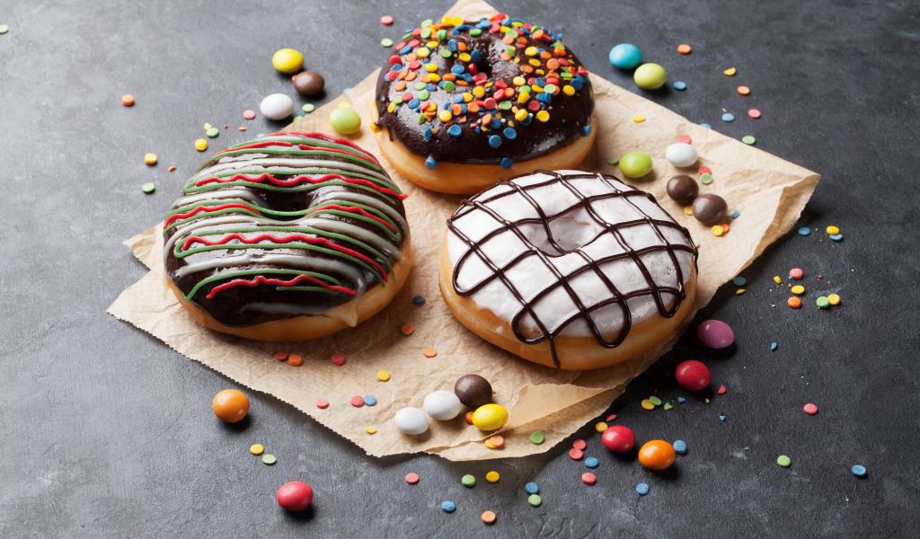 Три аппетитных сладких пончика с конфетами 