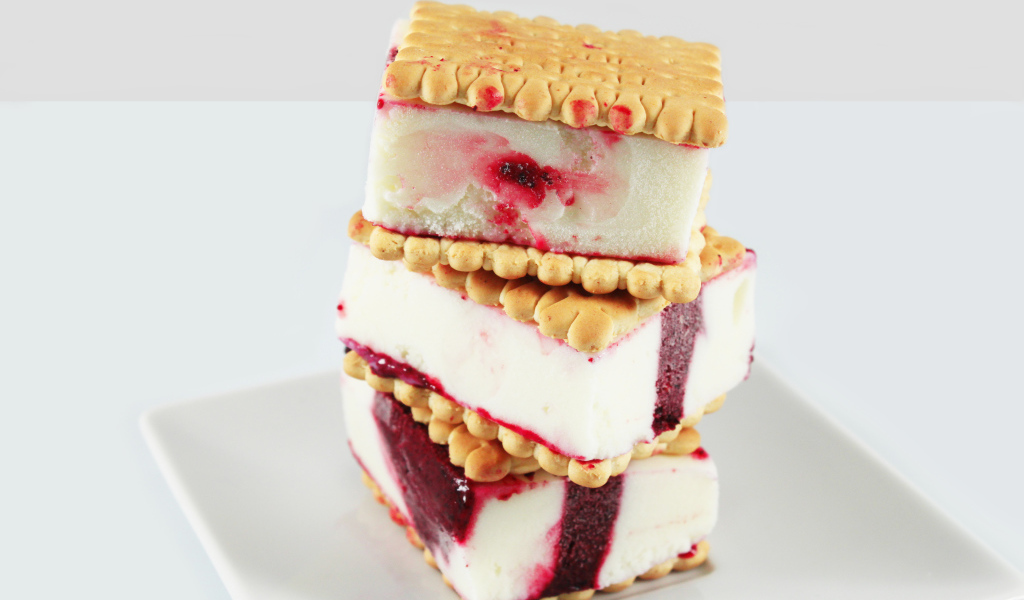 Три кусочка мороженого с печеньем на сером фоне