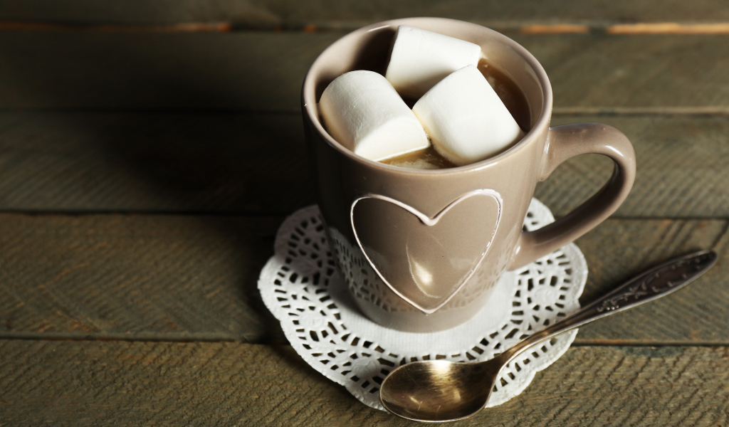 Чашка какао с кусочками маршмеллоу на кружевной салфетке