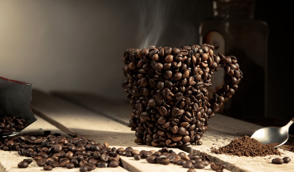 Чашка из кофейных зерен с горячим кофе 