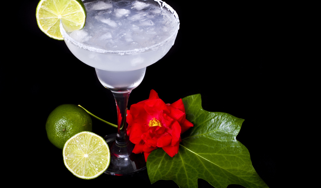 Бокал коктейля со льдом и лаймом на черном фоне