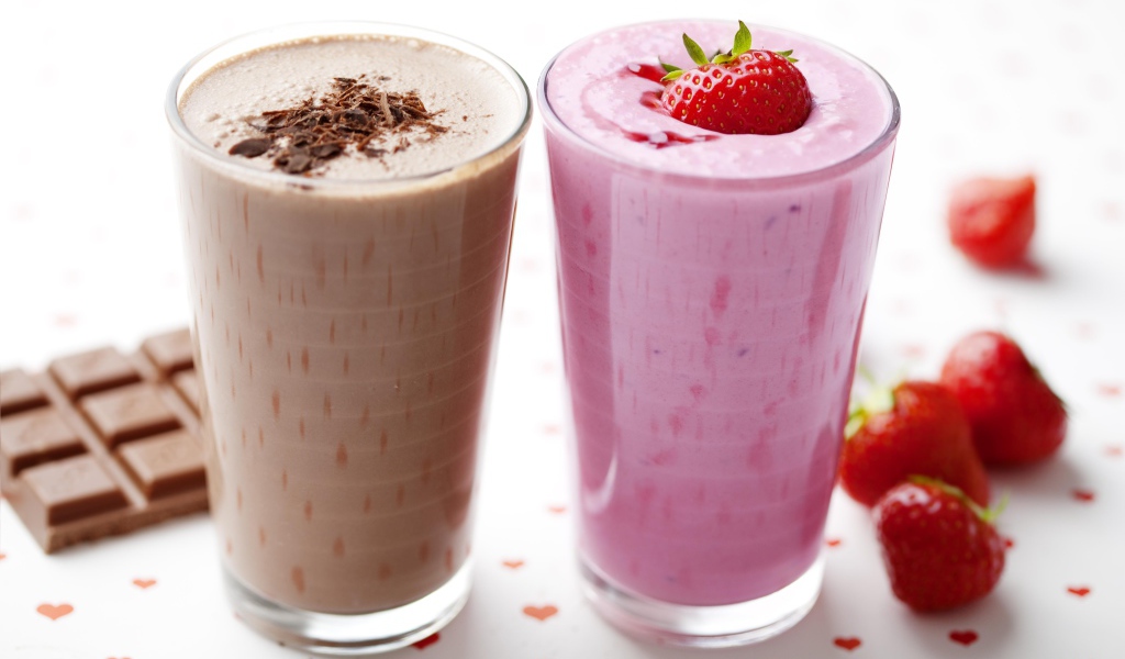 Шоколадное и клубничное смузи в стаканах на столе
