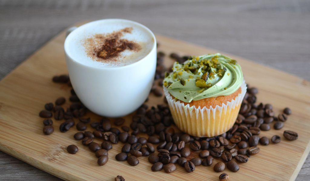 Кофе с аппетитным капкейком стоят на кофейных зернах