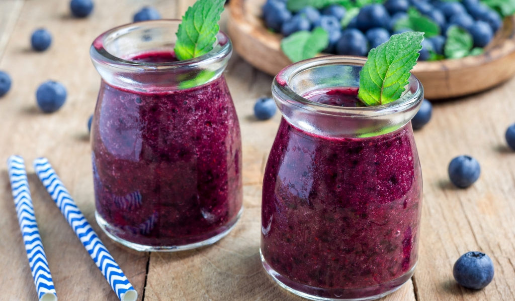 Вкусный черничный смузи с ягодами свежей черники на столе