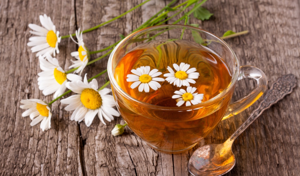 Стеклянная чашка чая с ромашкой