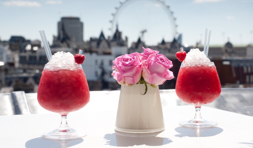 Два коктейля со льдом на столе с цветами