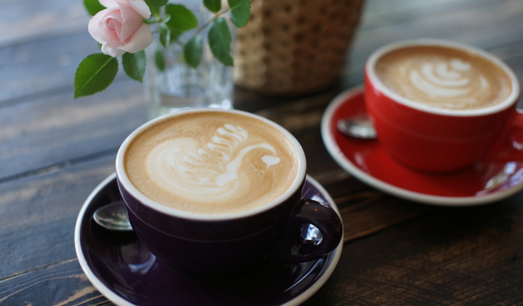 Две чашки кофе на столе с розовой розой