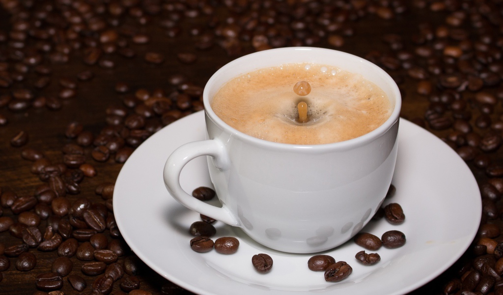 Белая большая чашка кофе с зернами на столе