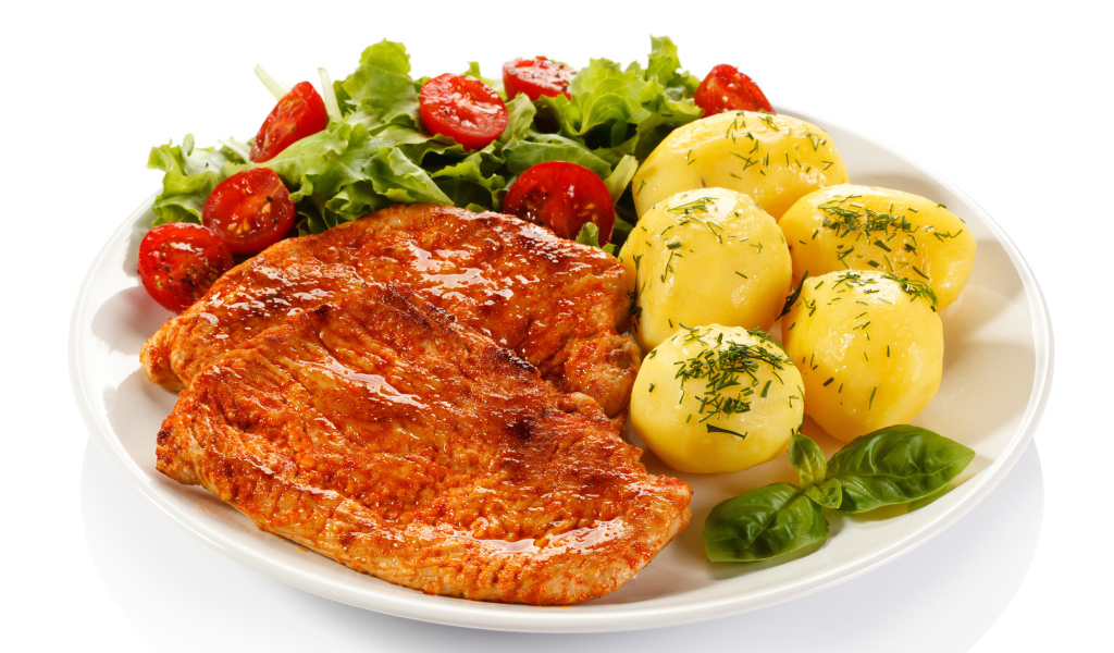 Аппетитные отбивные с вареным картофелем и салатом на белой тарелке