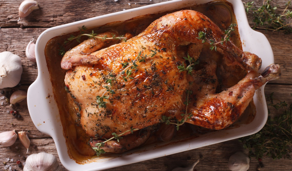 Запеченная аппетитная курица на со специями на столе