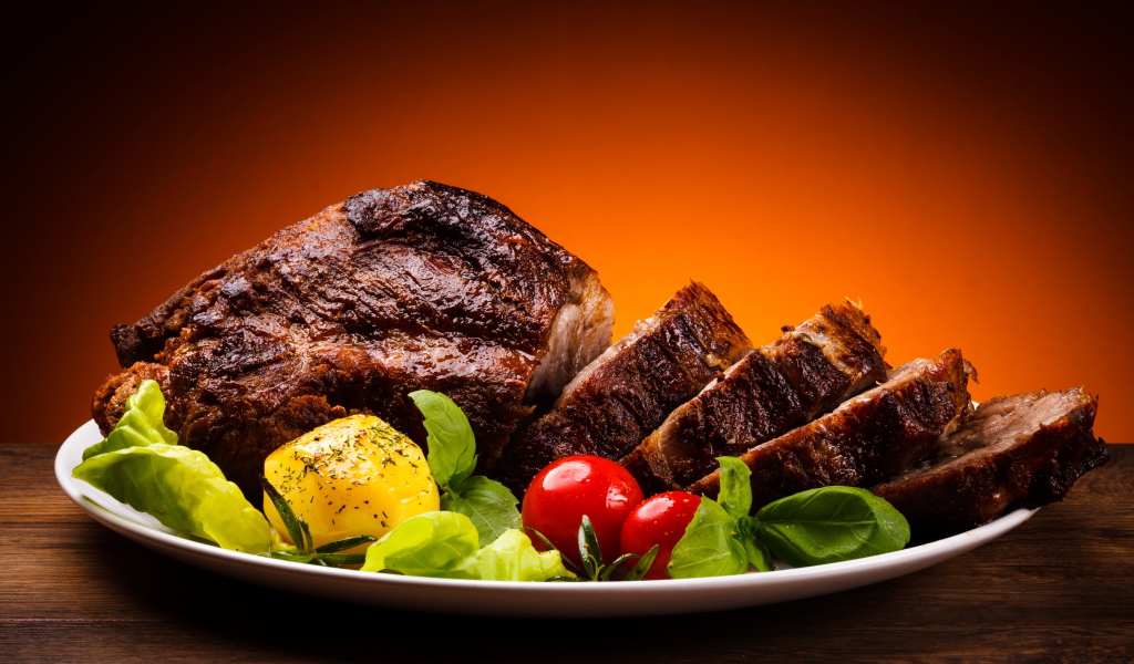 Нарезанное жареное мясо с овощами на блюде