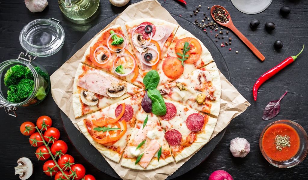 Аппетитная пицца на столе со специями и помидорами