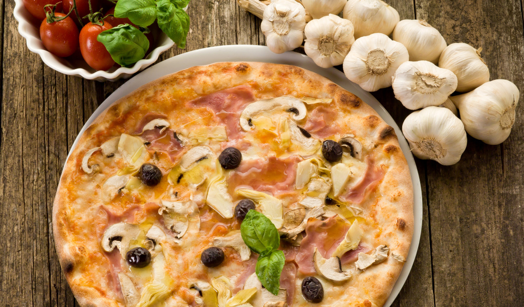 Свежая пицца с грибами на столе с чесноком и помидорами