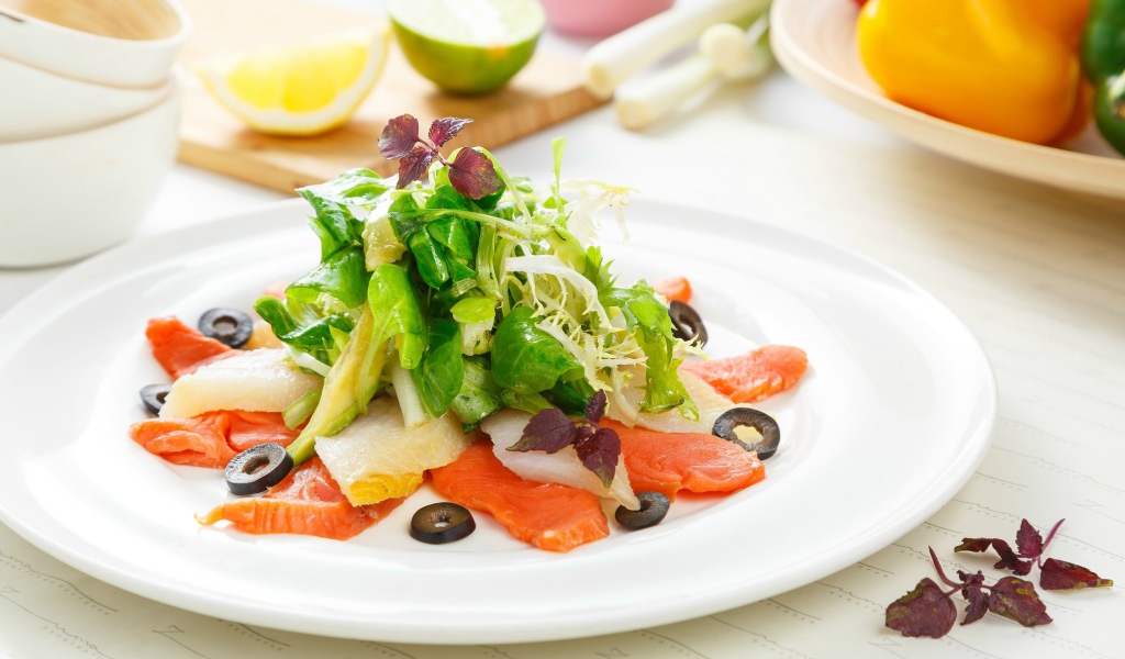 Аппетитный салат с морепродуктами на белой тарелке 