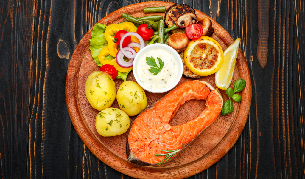 Жареный кусок рыбы с овощами и соусом