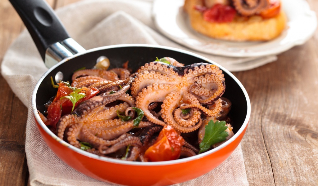 Осьминоги в сковороде на столе 