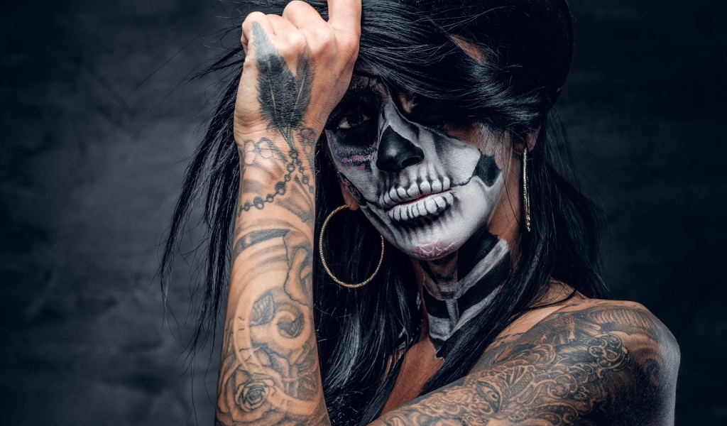 Брюнетка с татуировками и мейкапом на лице 