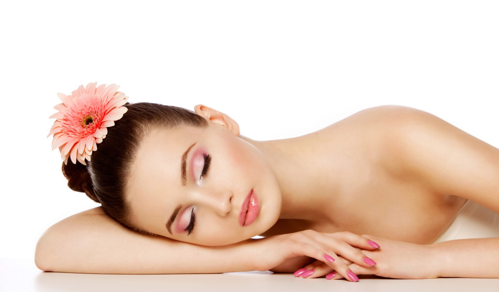 Нежная спящая девушка с красивым макияжем с цветком герберы в волосах