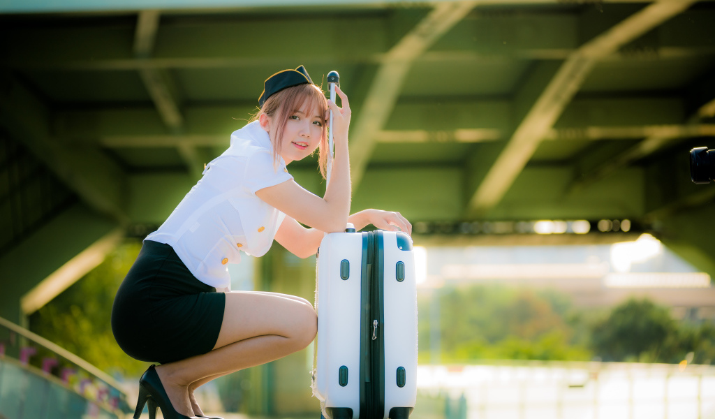 Девушка азиатка стюардесса с чемоданом