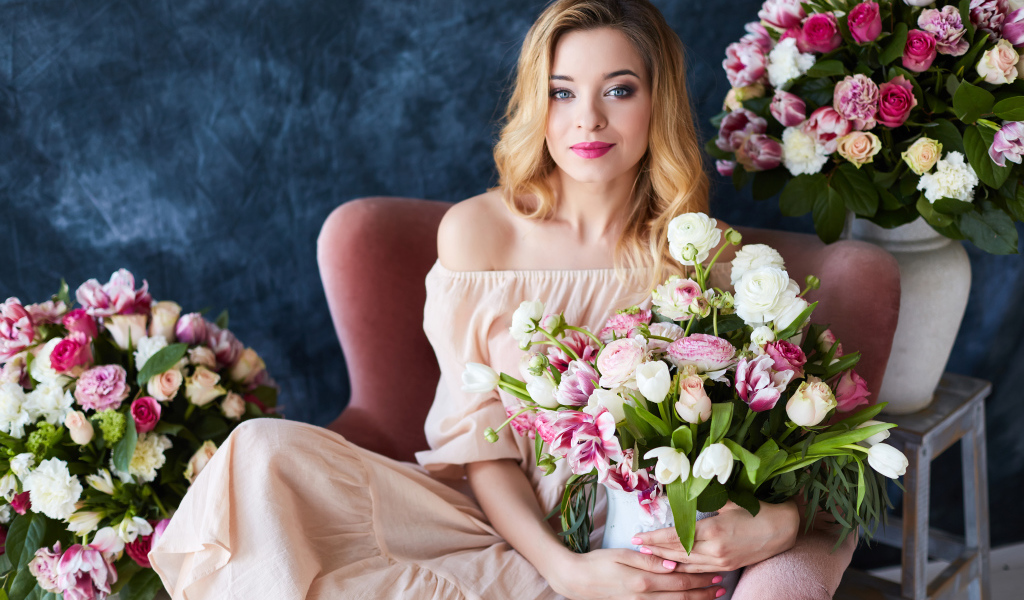 Красивая девушка блондинка сидит с букетом цветов