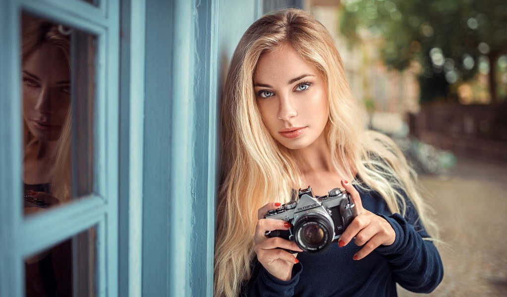 Красивая девушка блондинка с фотоаппаратом 