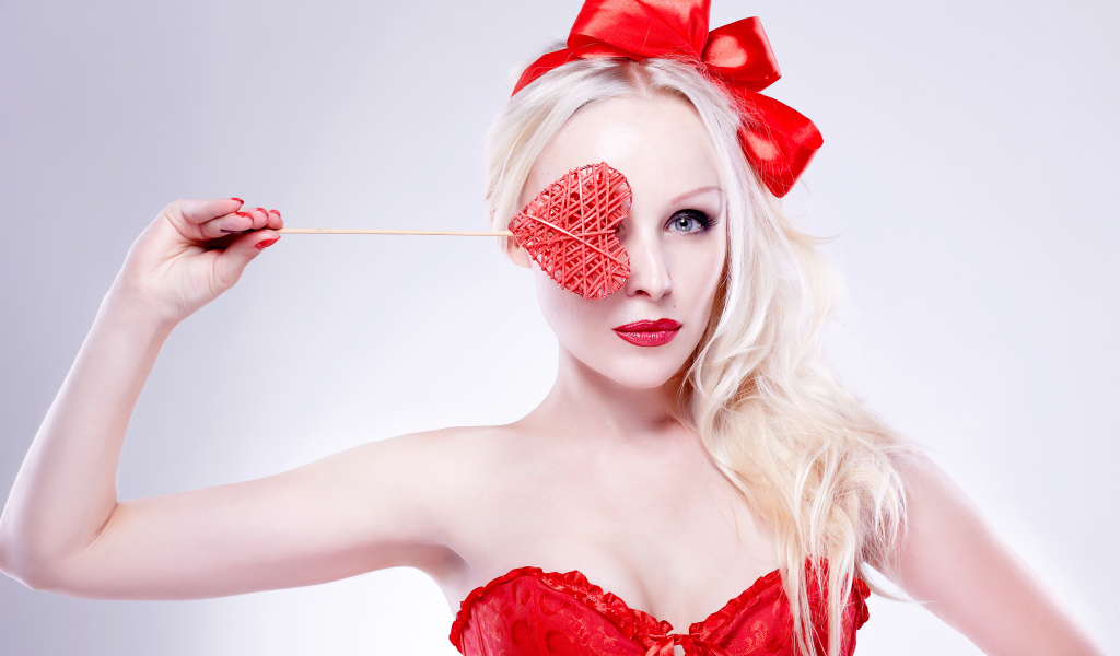 Красивая девушка блондинка в красном наряде с сердечком в руке