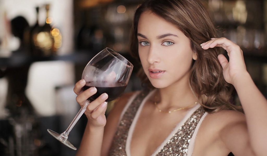 Красивая голубоглазая девушка с бокалом красного вина в руке