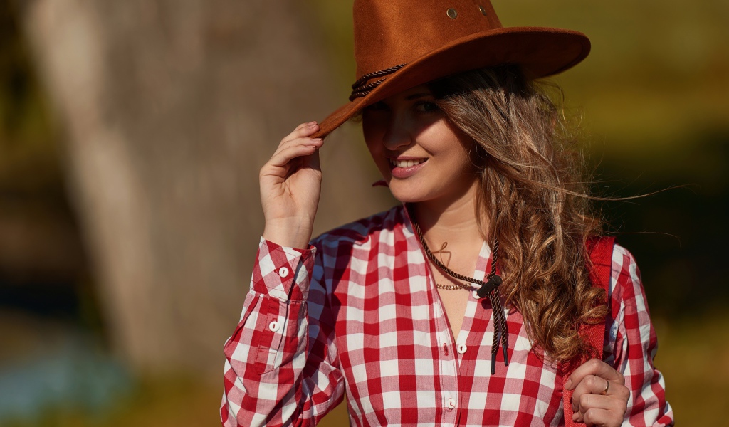 Красивая девушка брюнетка в ковбойской шляпе 