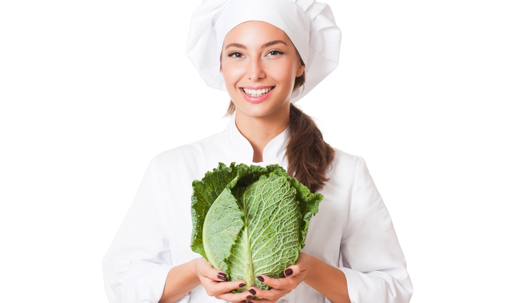 Красивая девушка повар с зеленой капустой в руках
