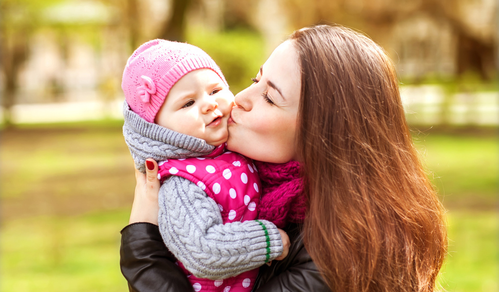 Красивая девушка держит в руках маленького ребенка