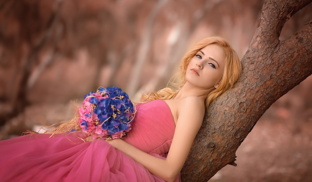Красивая девушка в розовом платье с букетом 