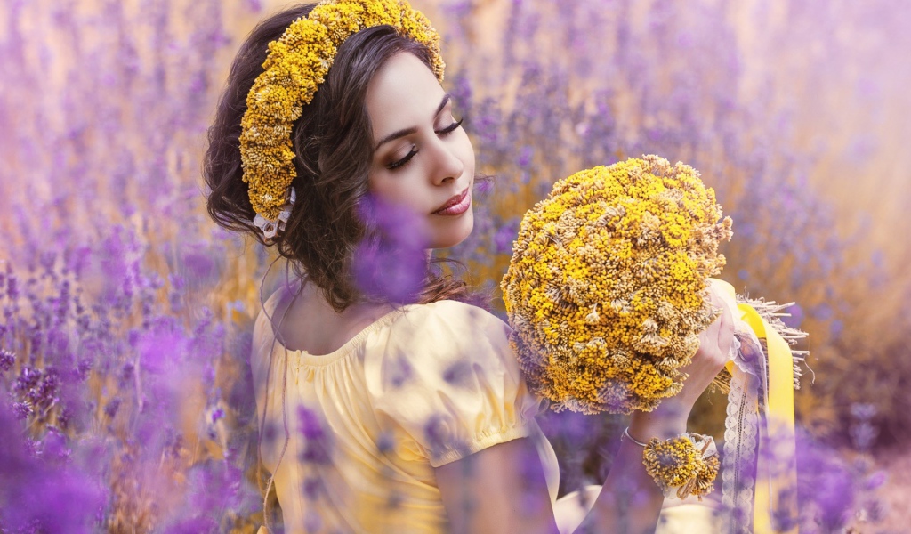 Красивая девушка с букетом желтых полевых цветов 