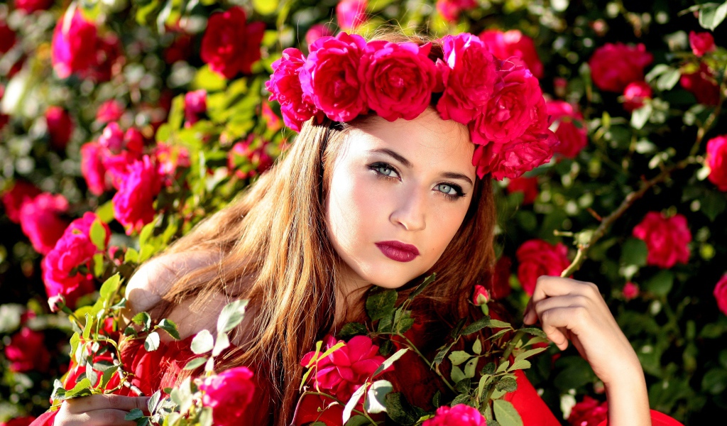 Красивая девушка с венком из красных роз на голове 