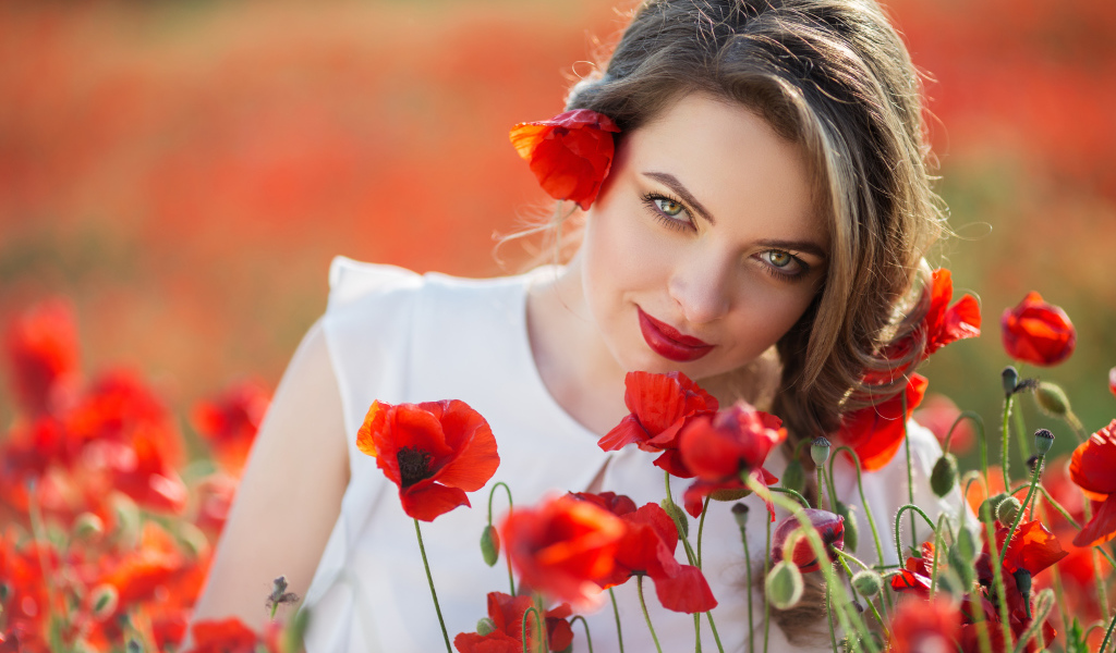 Красивая девушка с выразительным взглядом на поле с красными маками