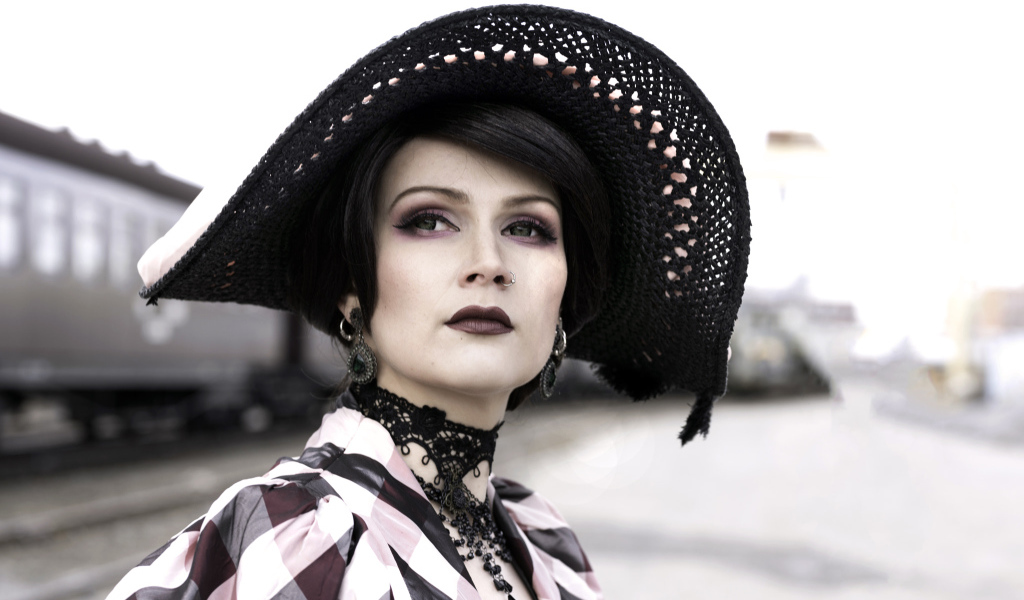 Красивая зеленоглазая девушка в большой черной шляпе