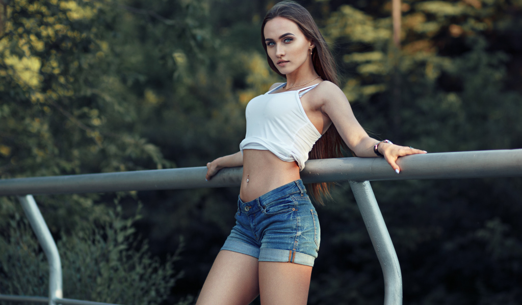 Красивая стройная девушка в джинсовых шортах