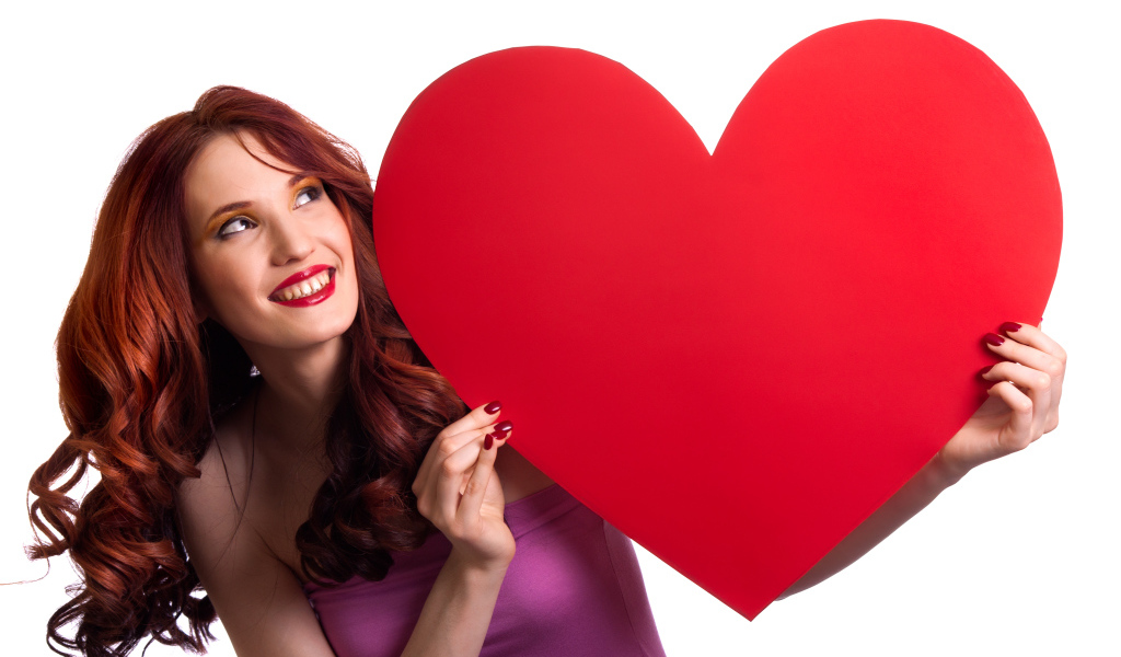 Красивая улыбающаяся девушка с большим красным сердцем в руках