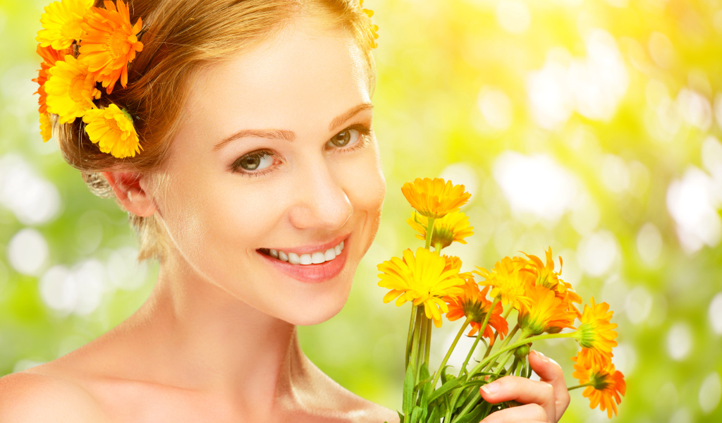 Красивая улыбающаяся девушка с цветами календулы в волосах