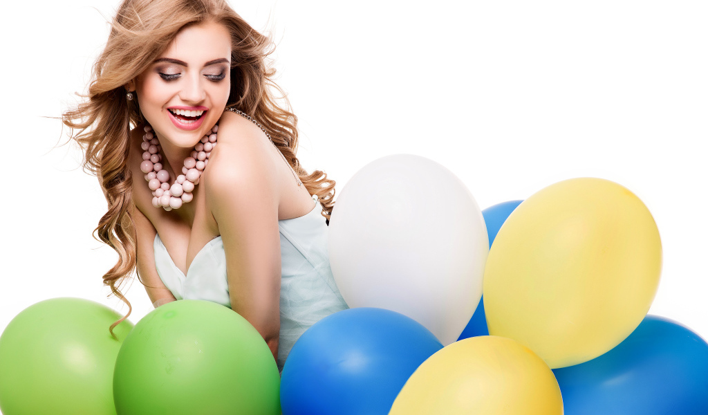 Красивая улыбающаяся девушка с разноцветными шариками на белом фоне