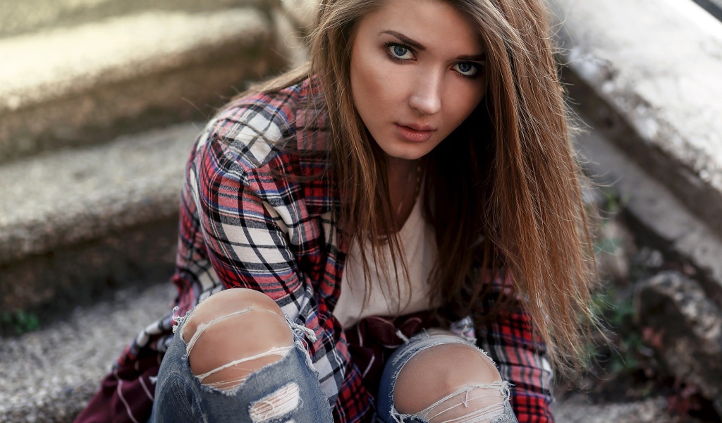 Голубоглазая девушка брюнетка в модных джинсах 