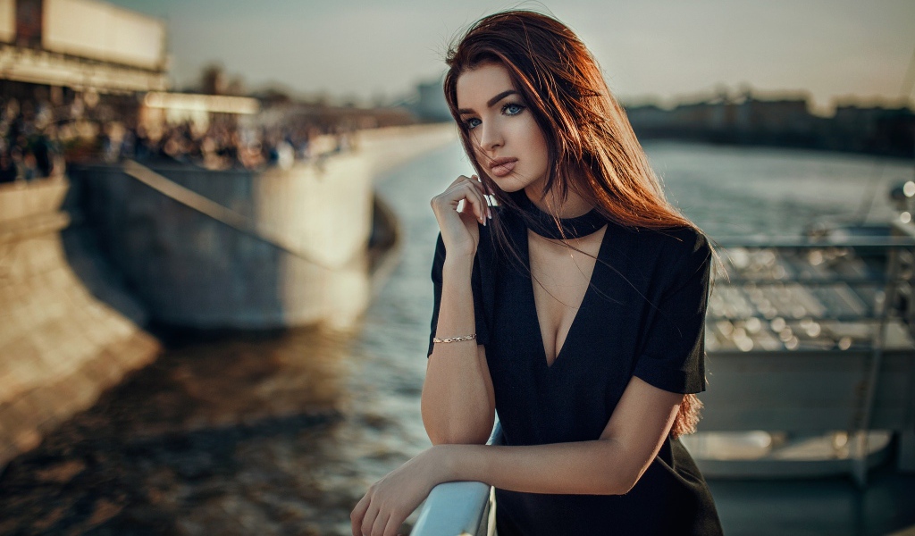 Голубоглазая девушка брюнетка в черном платье у воды 