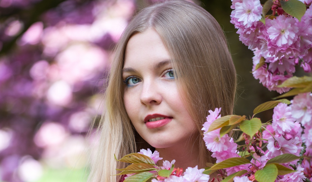 Милая голубоглазая девушка с розовыми цветами 