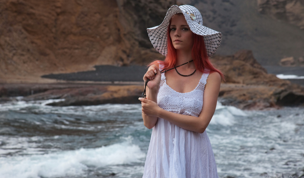 Рыжеволосая девушка в шляпе и белом платье у реки