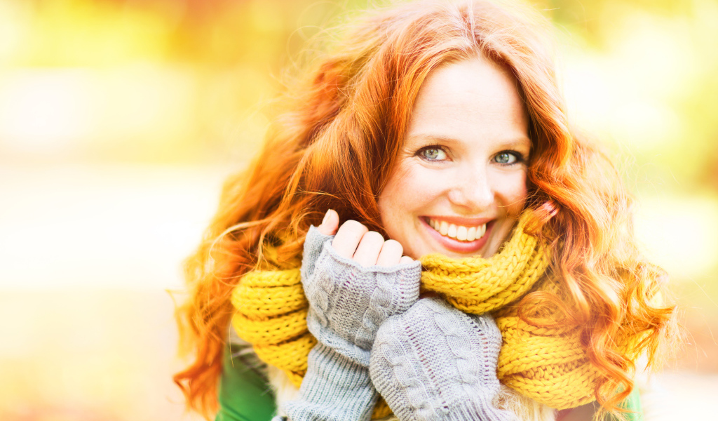 Улыбающаяся рыжеволосая девушка в теплом шарфе