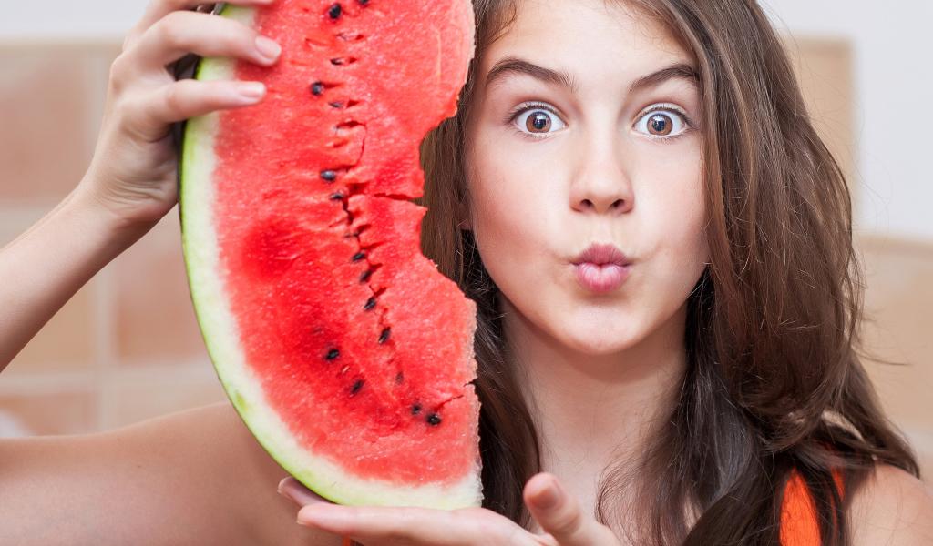 Девушка держит в руках скибку арбуза