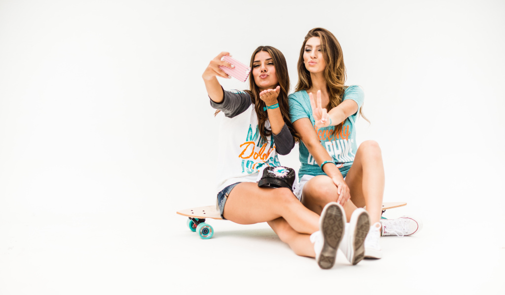 Две красивые девушки делают селфи на телефон