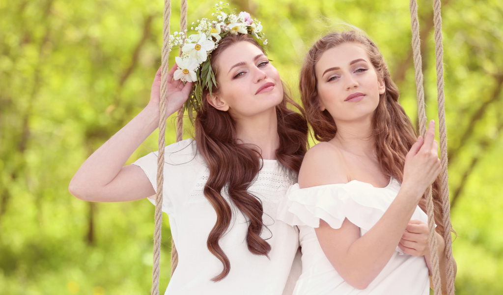 Две красивые длинноволосые девушки шатенки на качели