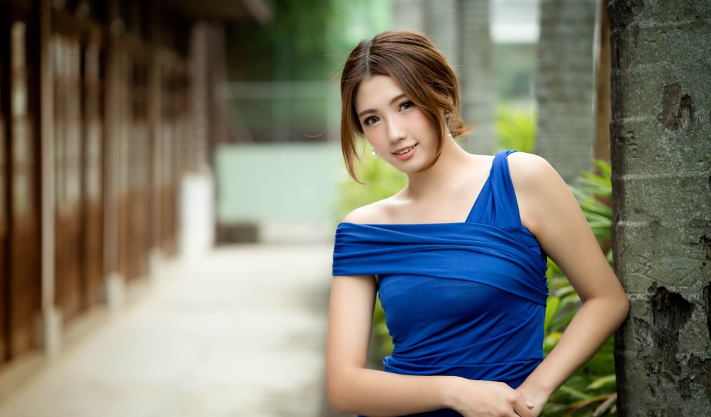 Молодая девушка азиатка в красивом голубом платье