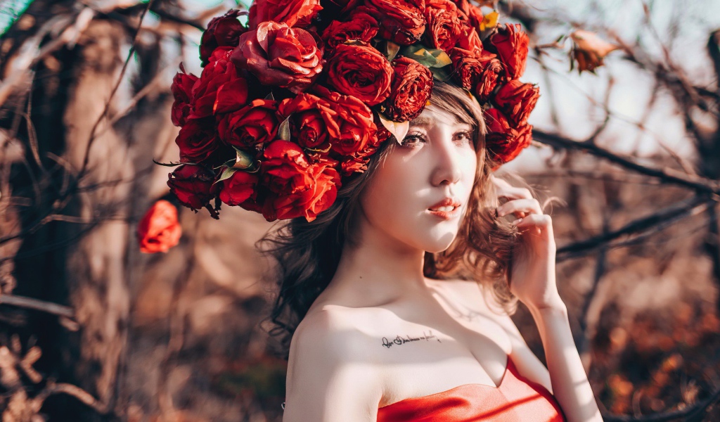 Молодая девушка азиатка с красными цветами на голове